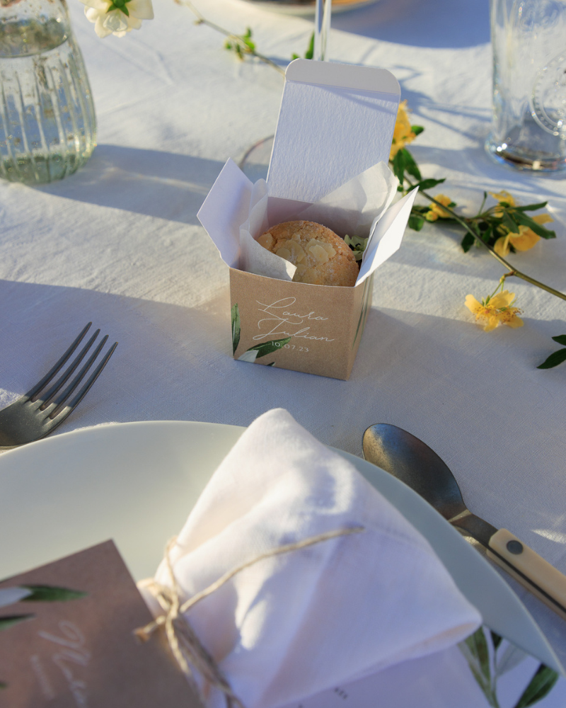 cube surprise déposé sur une table de mariage, avec à l’intérieur un macaron.