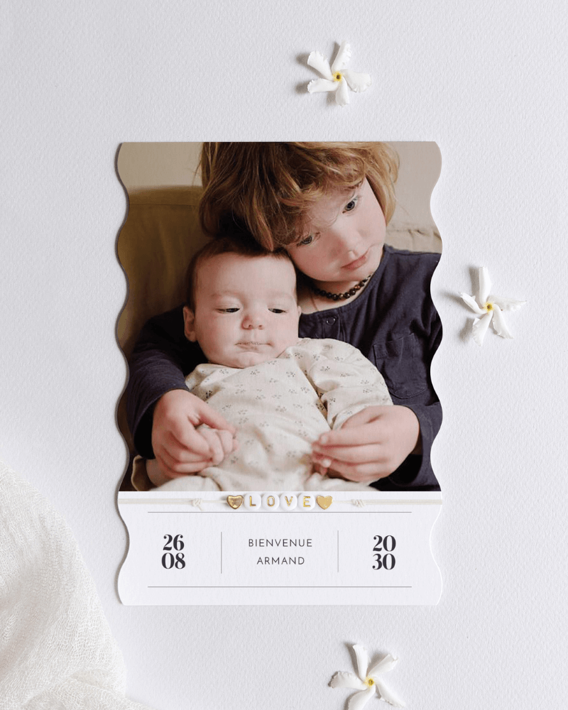 faire-part de naissance minimaliste aux bords ondulés avec photo d’une petite fille tenant dans ses bras un bébé.