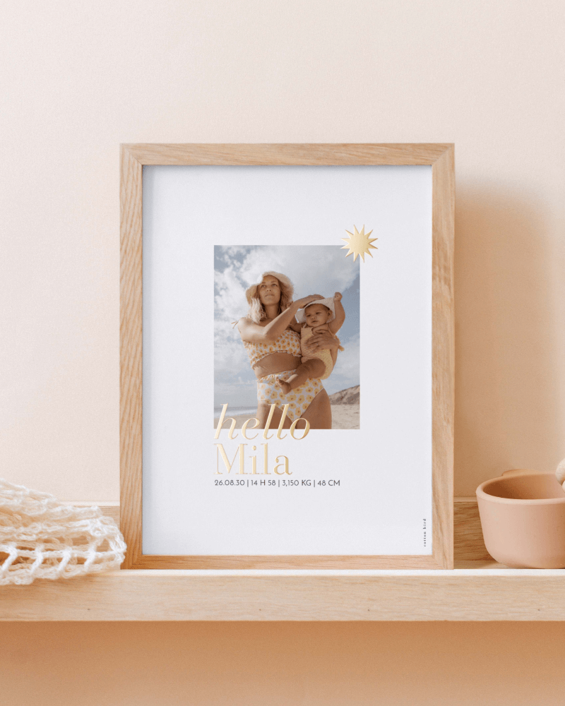 une affiche de naissance avec photo de maman et bébé, et Hello, Mila écrit en lettres dorées.