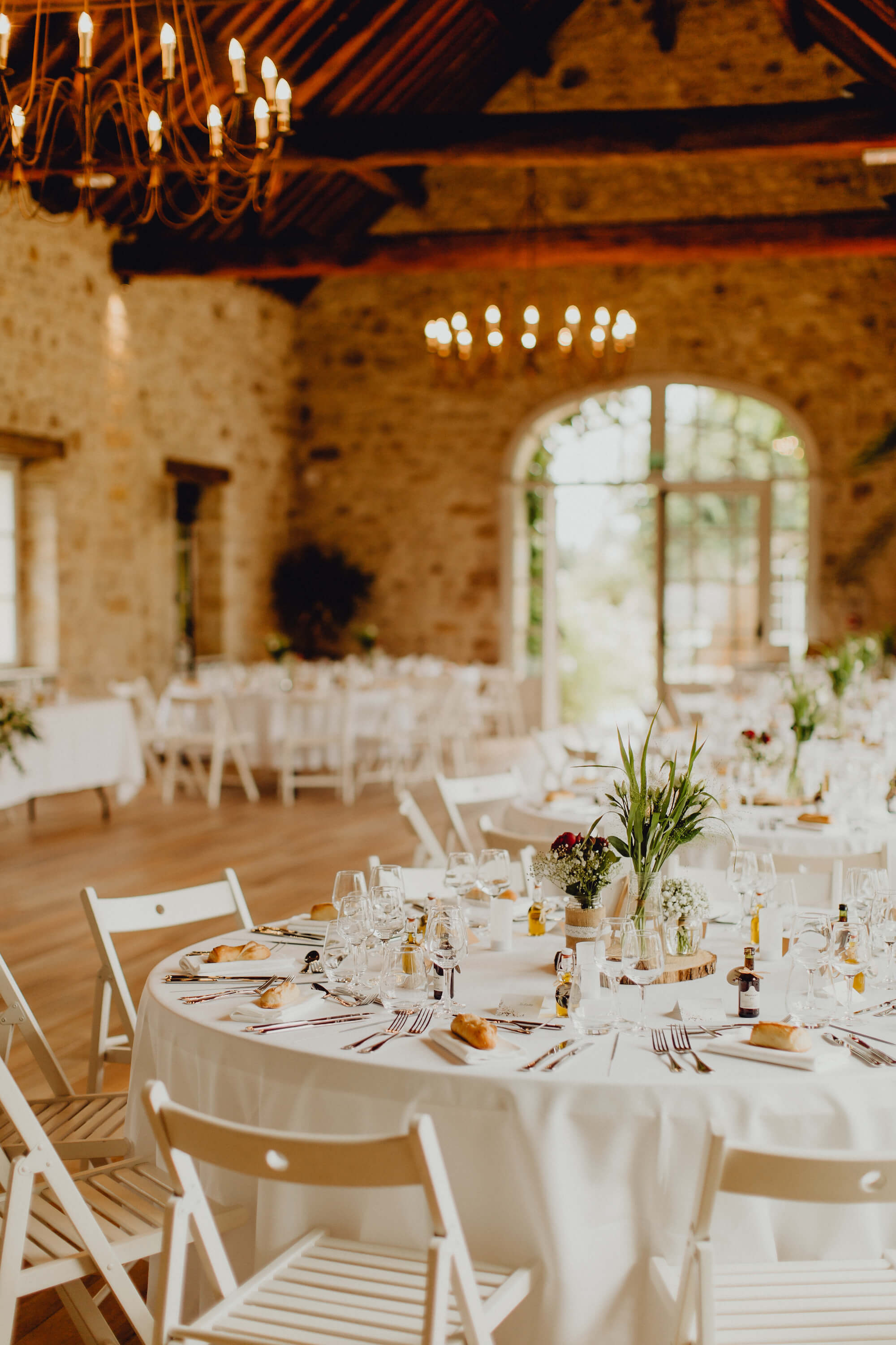 une table de mariage dans une salle avec murs en pierre.