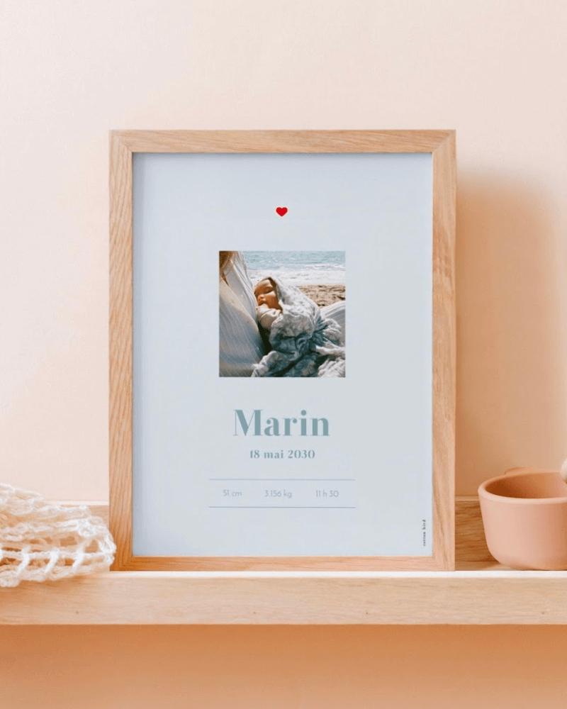 une affiche de naissance de couleur bleue, personnalisée avec une photo de maman et bébé et le prénom “Marin” 