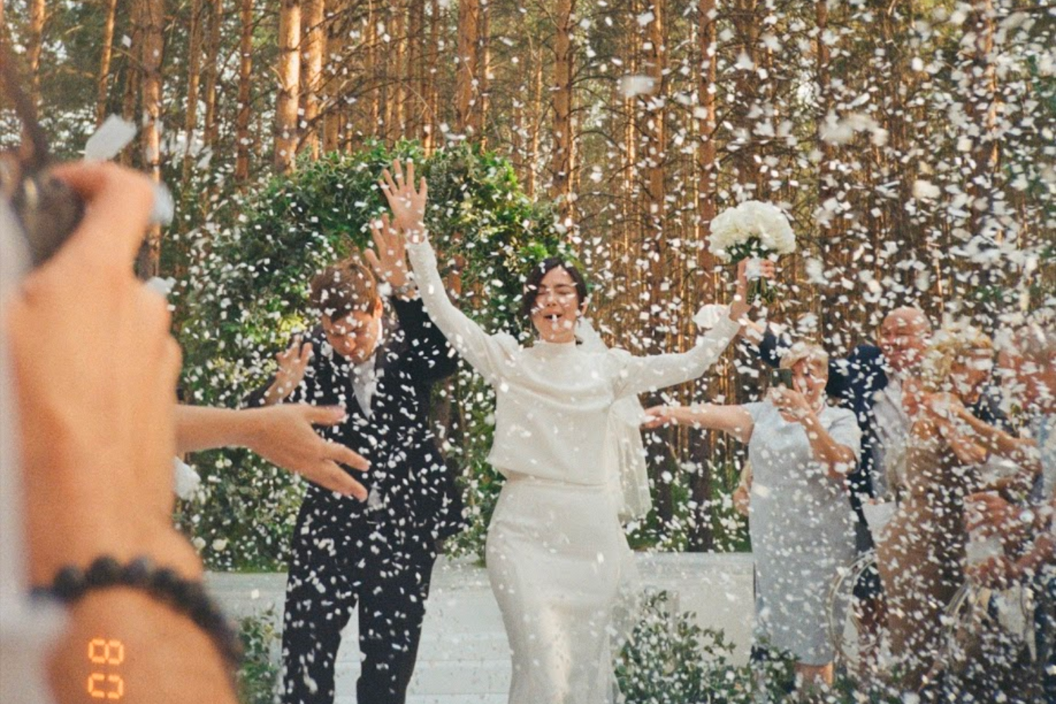 un couple de mariés à la fin de la cérémonie, sous une pluie de confettis.