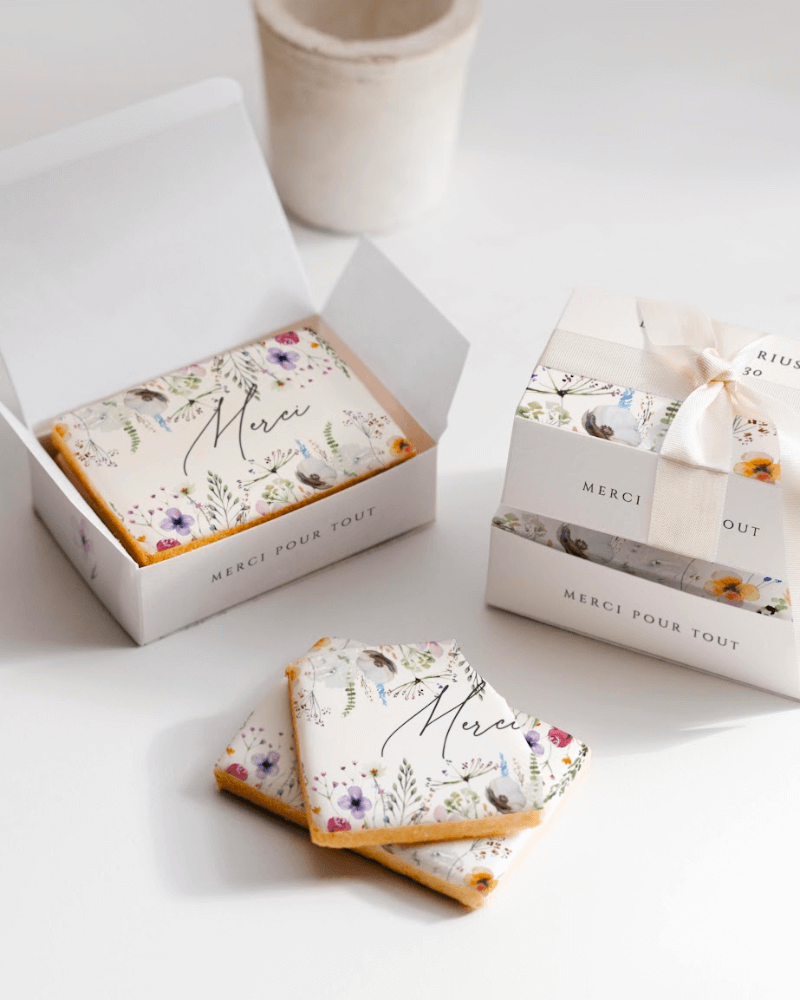 boîte à biscuits personnalisée décorée de jolies fleurs illustrées et remplies de biscuits, personnalisés.