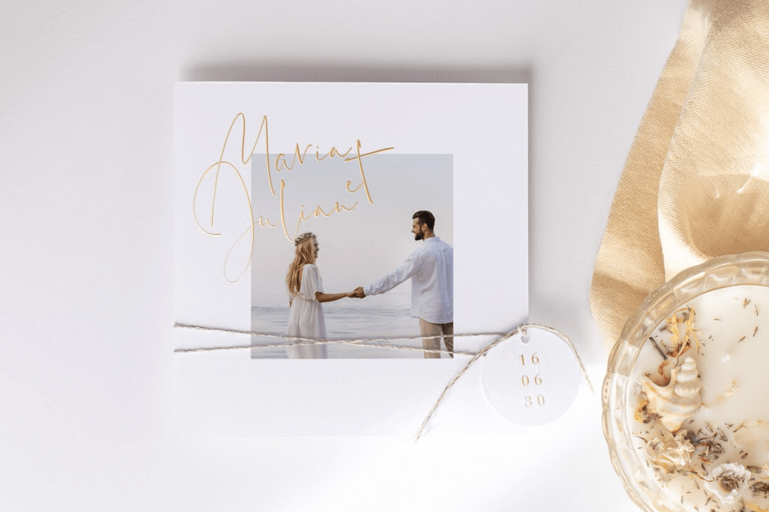 faire-part de mariage carré avec prénoms des mariés en finition dorée, photo du couple, agrémenté d’une étiquette personnalisée.
