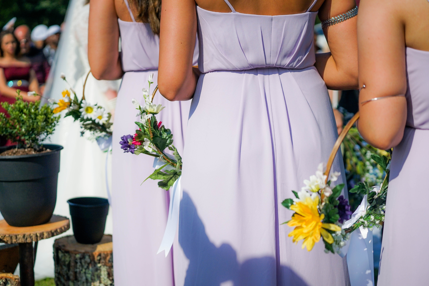 Des demoiselles d’honneur vues de dos, portant une couronne de fleurs et vêtues d’une robe couleur lilas.
