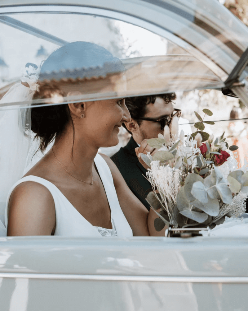 un couple de jeunes mariés dans une voiture vintage