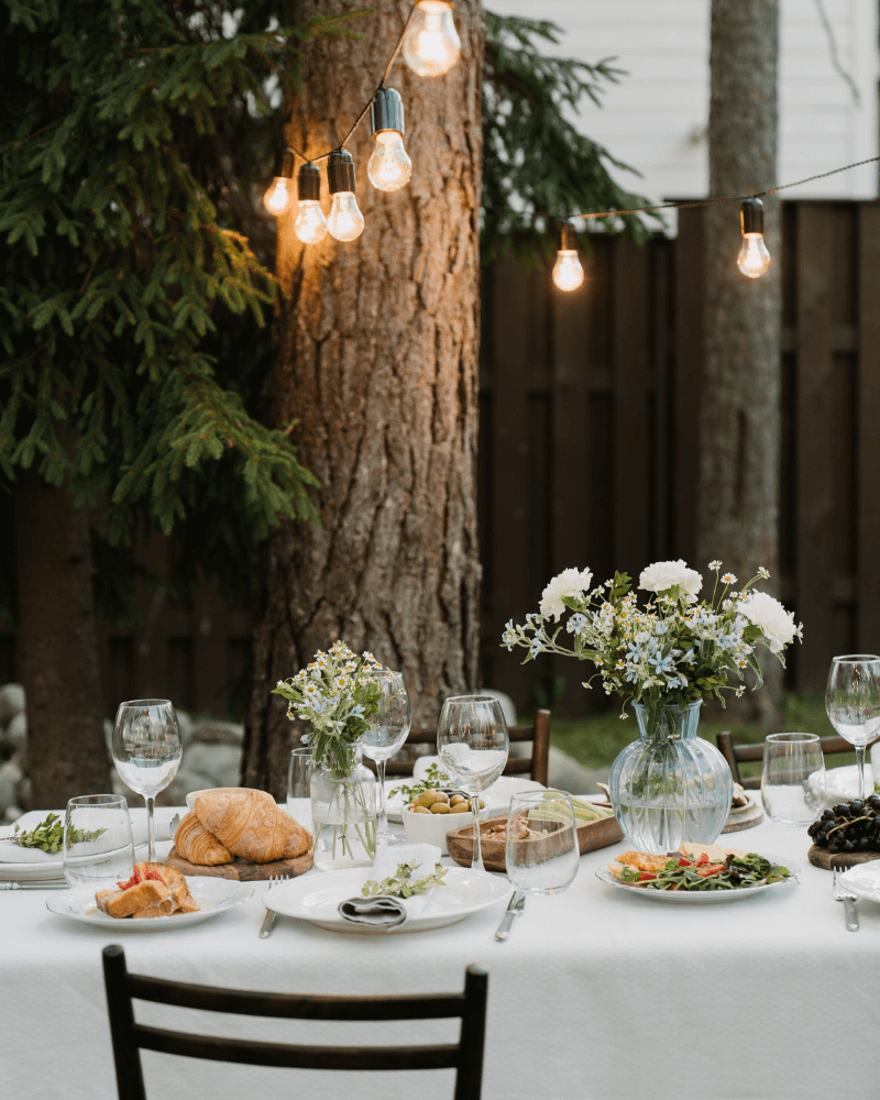 une table de brunch mariage avec une nappe blanche, des assiettes garnies de légumes.