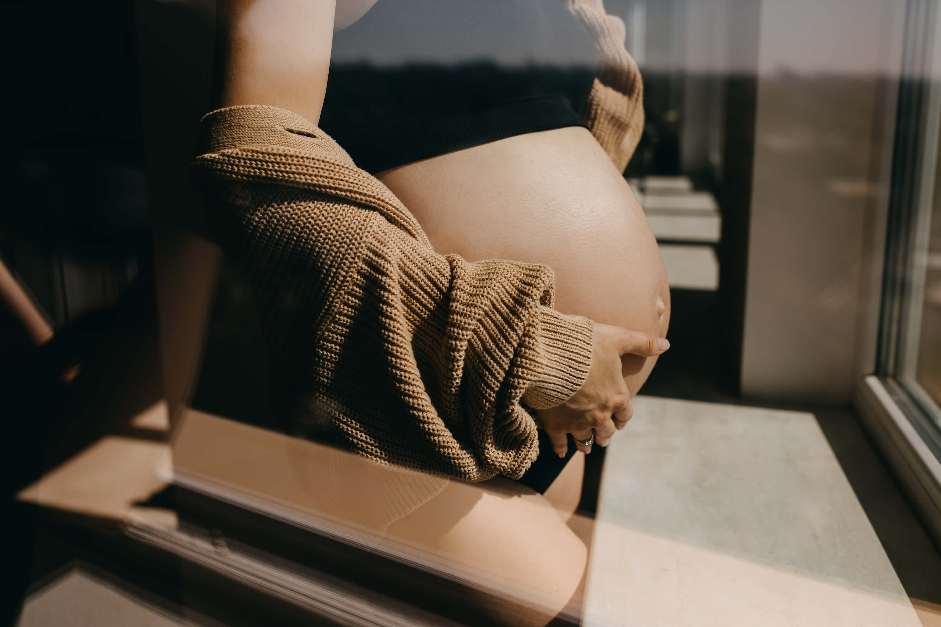 femme enceinte se tenant devant une fenêtre