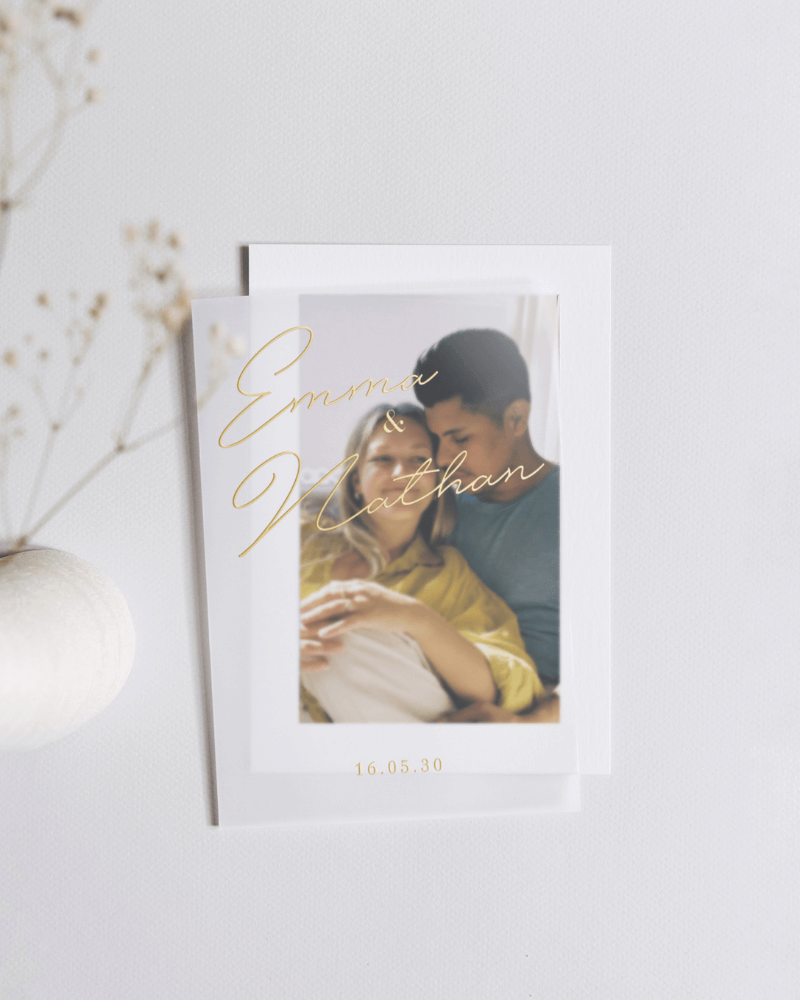 faire-part de mariage avec lettrage doré, calque et photographie d’un couple enlacé.
