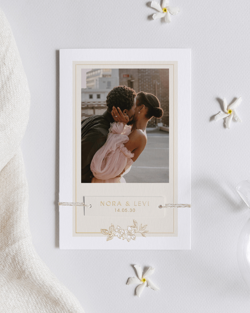 faire-part de mariage avec finitions dorées et photographie d’un couple s’embrassant