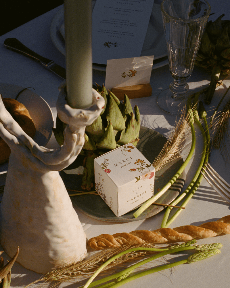 Une table de mariage décorée de fruits, de légumes et d'un petit cube surprise illustré cotton bird.