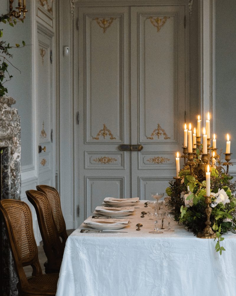 table de mariage recouverte d’une nappe blanche et décorée de longs bougeoirs.