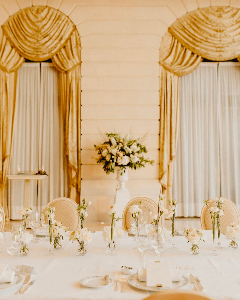 table de mariage dans un décor de château avec de grands rideaux couleur or