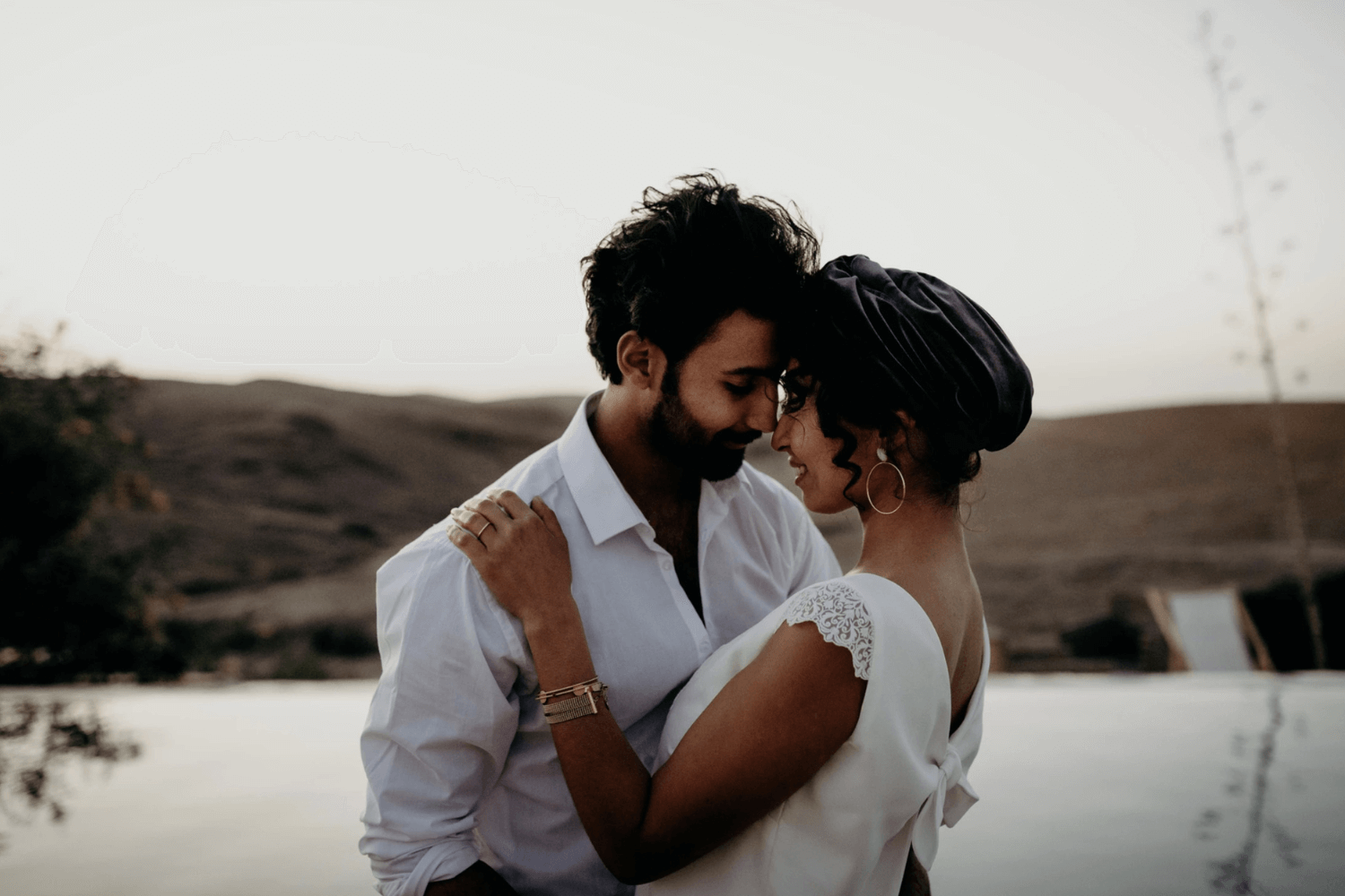 Un couple de jeunes mariés enlacés, se regardant dans les yeux.